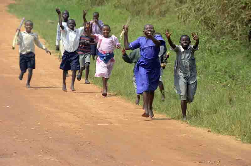 41 - Uganda - carretera - jovenes saludando